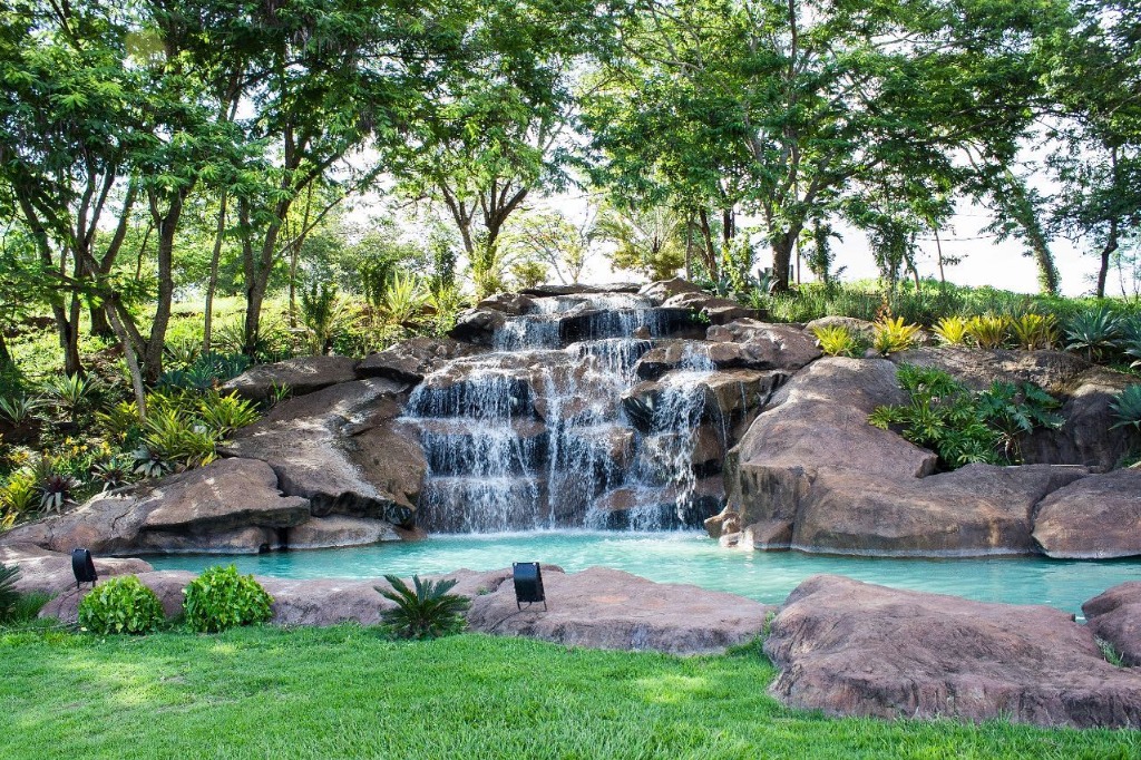 Cascata natural com piscina e jardim exuberante